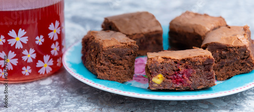 Red tea, brownies closeup on a blue, round plate