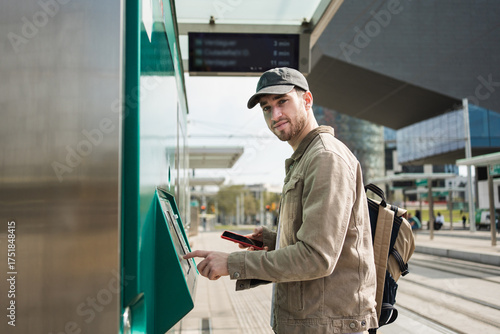 Photography Young trendy man buying public transport ticket at automatic train tram ticket m