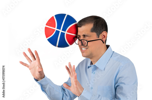 Businessman with blue shirt playing sport being hit by a basket ball with force in the face when he misses a catch or as an unexpected accident to a spectator,against a white background