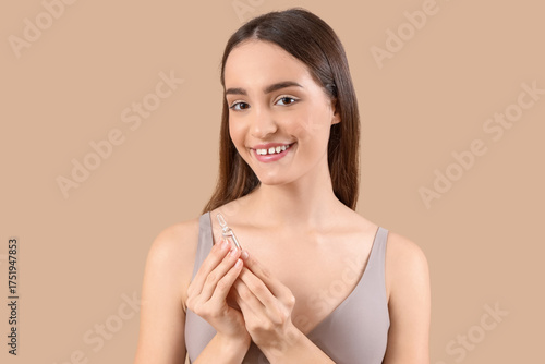Young woman with ampoule on...