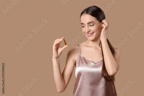 Young woman with ampoule on...