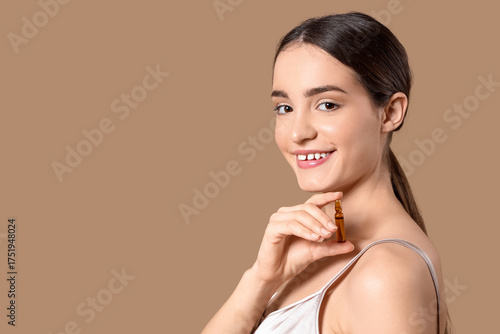 Young woman with ampoule on...