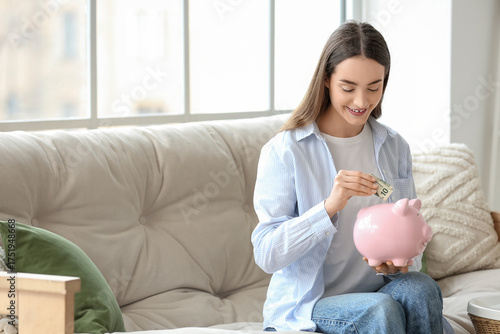 Young woman putting money i...