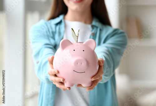 Young woman with piggy bank...