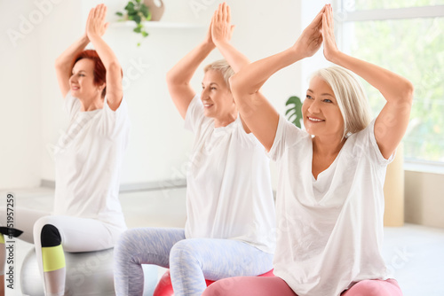 Mature women doing yoga on ...