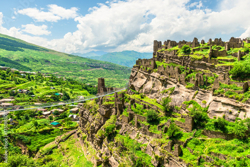 Ruins of the old village of Kakhib on a green mountain slope. North Caucasus