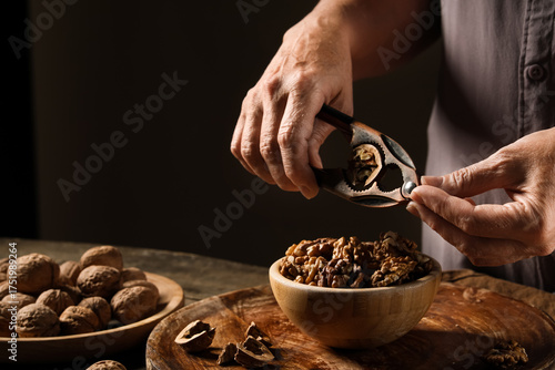 Elderly woman cracking waln...