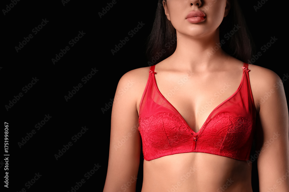 Fototapeta premium Beautiful young woman in red lace bra on dark background