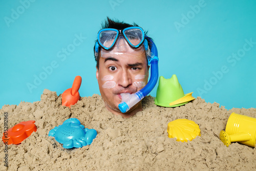 Man buried in sand with snorkel and goggles beach humor