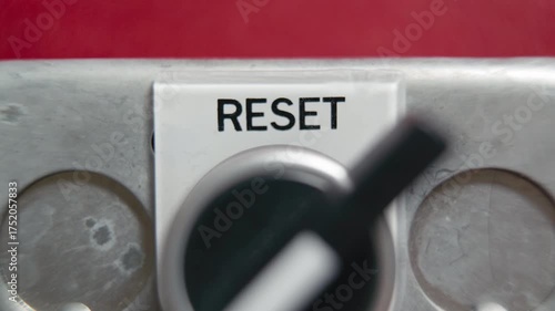 Turning a reset knob on a red wall