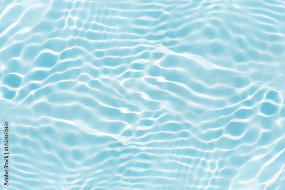 Obraz premium Blue water with ripples on the surface. Defocus blurred transparent blue colored clear calm water surface texture with splashes and bubbles. Water waves with shining pattern texture background.