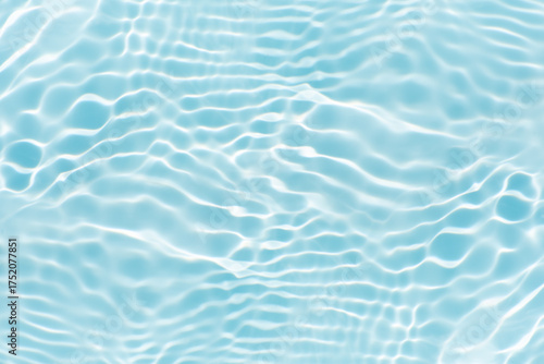 Blue water with ripples on the surface. Defocus blurred transparent blue colored clear calm water surface texture with splashes and bubbles. Water waves with shining pattern texture background.