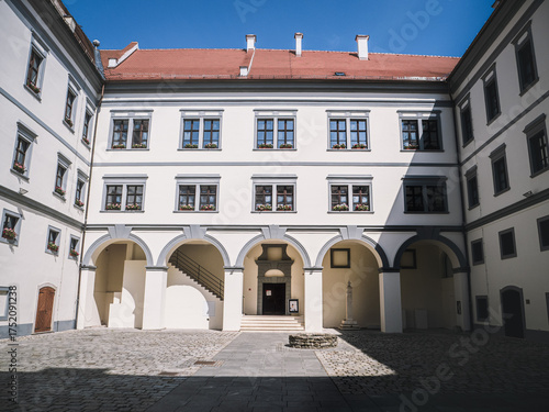 The inner courtyard of Stari Grad Castle in Cakovec, Croatia features elegant arches, cobblestone paving, and bright façades. A well-preserved historic landmark blending Renaissance and Baroque styles