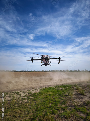 Vertical photo of a large agricultural drone landing to reload fertilizer.