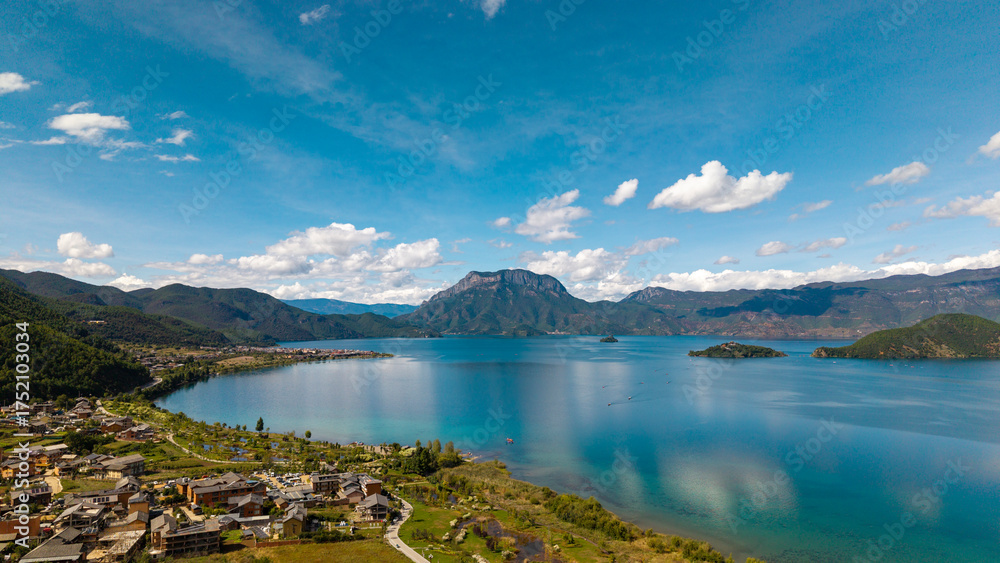 Naklejka premium Villages by the Sunrise Lake and distant mountains, Lugu Lake in Sichuan, China