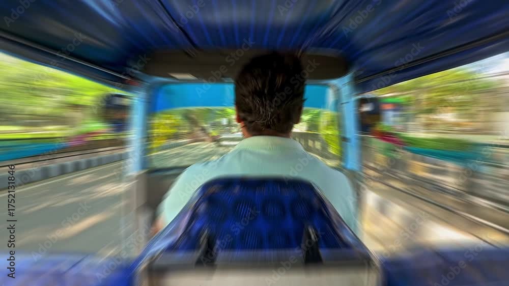 Auto rickshaw driver navigating through busy streets with motion blur ...