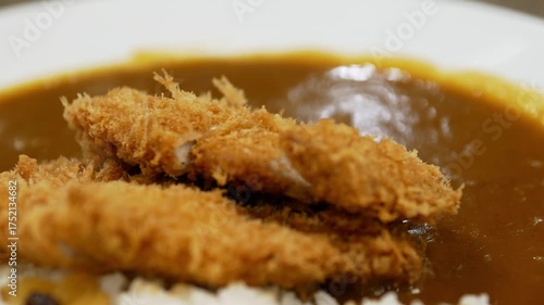 Panning close-up shot of hot Japanese curry rice with a  pork cutlet.