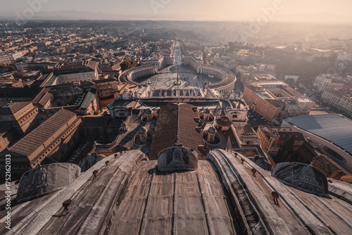 Roof of Basilica di San Pietro in Vatican City and walking tourist crowd on piazza, Rome, Italy