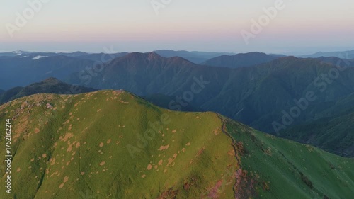 Golden light hits ridge trail and Tsurugi mountain peak with beautiful morning landscape