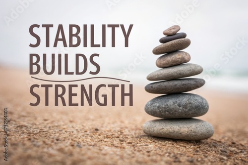 Stone pyramid balancing upward on sandy beach with text