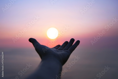 Hands outstretched toward the bright rising sun, a hopeful New Year sunrise background
