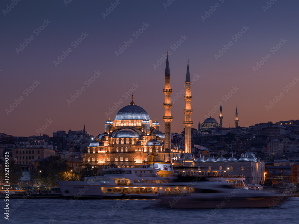 Obraz premium Cityscape with illuminated New mosque Yeni Camii against colorful sky at dusk, Istanbul, Türkiye