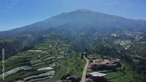 Majestic Mountain Landscape with Terraced Fields and Village Below.