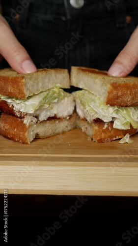 Girl opening crispy chicken Caesar toast sandwich with hands to show the filling