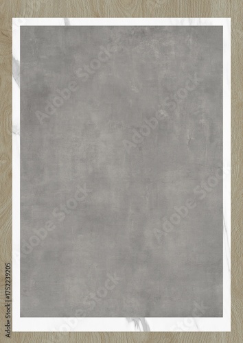 Gray textured surface framed by white border on wooden background