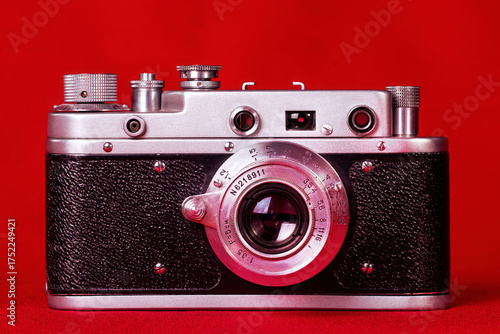 Old film 35 mm compact camera on red background, isolated.