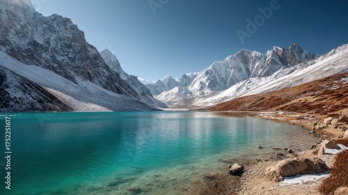 Beautiful snow capped mountain range beside clear turquoise blue lake. Scenic icy landscape for travel and nature concept.