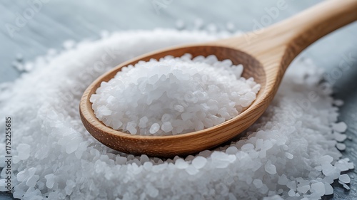 Wooden scoop overflowing with coarse crystalline salt granules