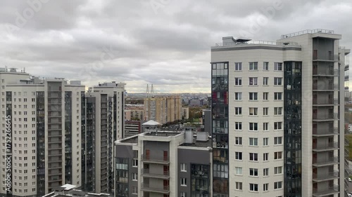 Clouds quickly float over high-rise buildings in the St. Petersburg area. A bridge is visible in the distance.