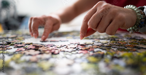 Woman's Hands Putting A Puzzle Together On The Table, A Hobby For The Whole Family
