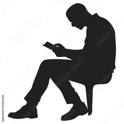 Silhouette of a man sitting and reading a book deeply focused
