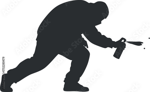 A silhouette of a graffiti artist spray painting on a wall in an urban setting.