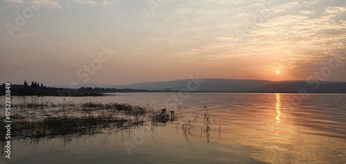 Fotografie Golden and Peaceful sunset reflection in the sea with mountain in the background