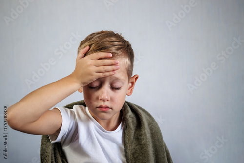 Little boy with headache touching his head