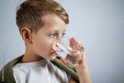Boy drinking water after taking medicine
