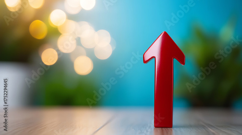 A red up arrow symbolizing growth and progress against a vibrant blue background with soft bokeh lights.
