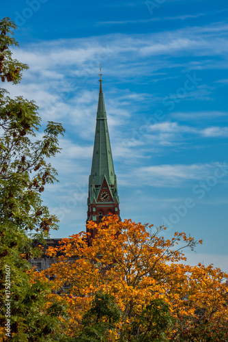 Canvas Print Autumn view through golden leaves towards St