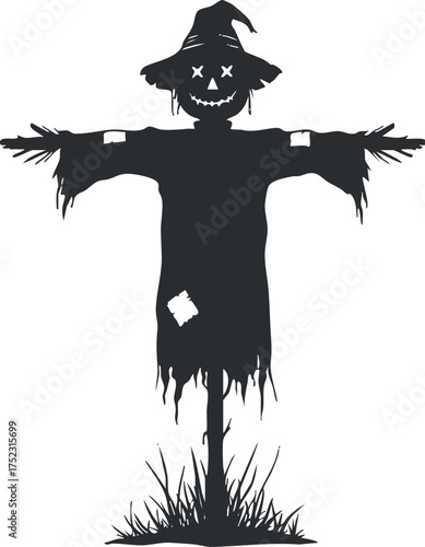 A silhouette of a traditional scarecrow standing in a field during autumn season.