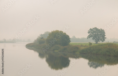 Beautiful landscape, river, trees covered with fog.