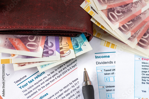  United Kingdom tax settlement. Tax forms. UK money wallet. Financial business concept. Filling out a form. Close up