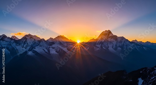 Majestic mountain range illuminated by a vibrant sunrise casting golden rays of light