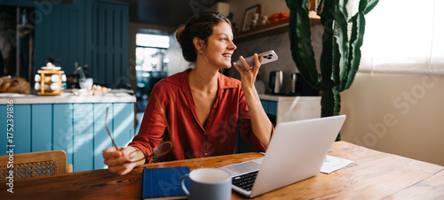 Woman chats on phone at home office