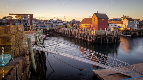 The historic architecture of the famous Rockport city in Massachusetts, USA showcasing its fishing boats and fisherman facilities on a sunny afternoon.
