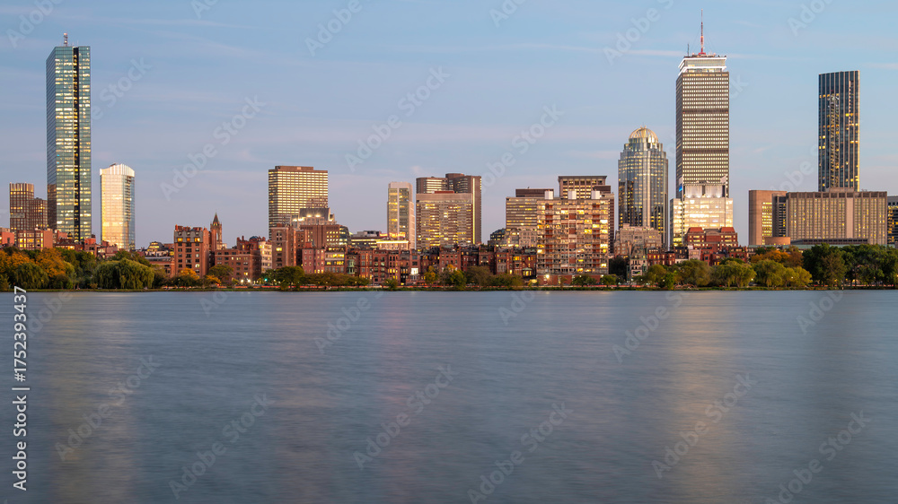 Obraz premium The skyline of Boston in Massachusetts at night as seen from Memorial Driver Road in Cambridge, MA, USA with the famous Charles river in between the two cities.