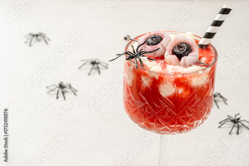 A glass of strawberry tea smoothie with whipped cream for Halloween