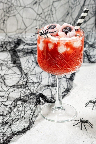 A glass of strawberry tea smoothie with whipped cream for Halloween